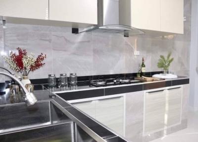 Modern kitchen with stainless steel appliances and marble backsplash