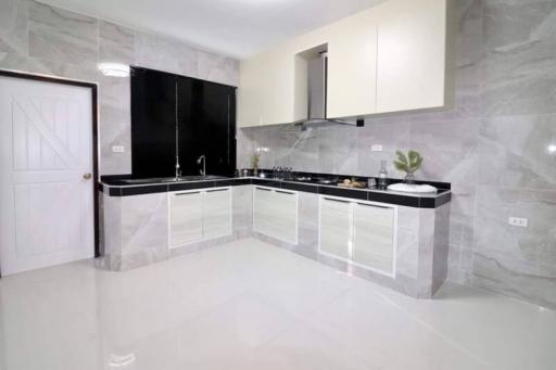Modern spacious kitchen with glossy countertops and marble flooring
