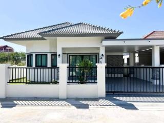 Modern single-story house with a tiled roof and fenced yard