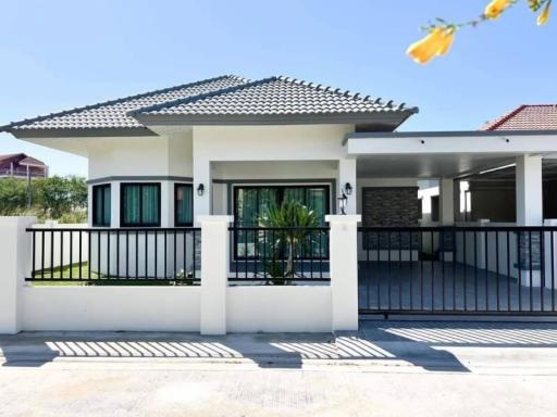 Modern single-story house with a tiled roof and fenced yard