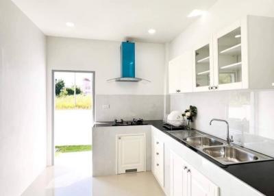 Modern white kitchen with stainless steel appliances and bright interior