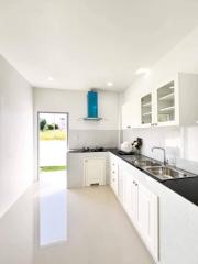 Modern white kitchen with stainless steel appliances and bright interior