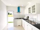 Modern white kitchen with stainless steel appliances and bright interior