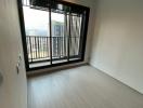 Empty bedroom with large window and balcony access