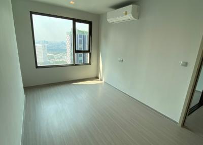 Bright and empty bedroom with large window and city view