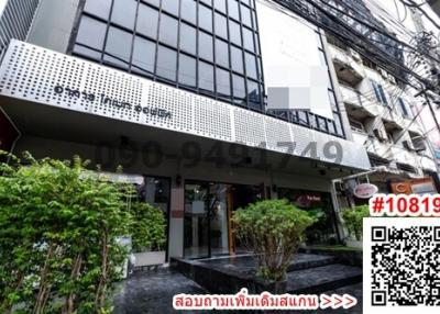 Modern commercial building facade with large windows and a business signage