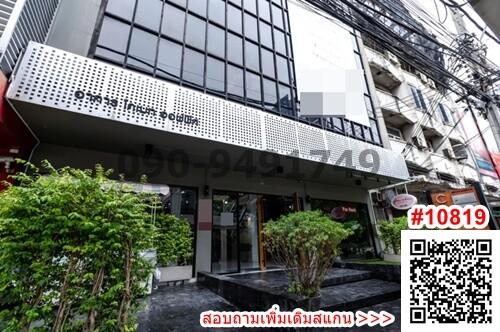 Modern commercial building facade with large windows and a business signage