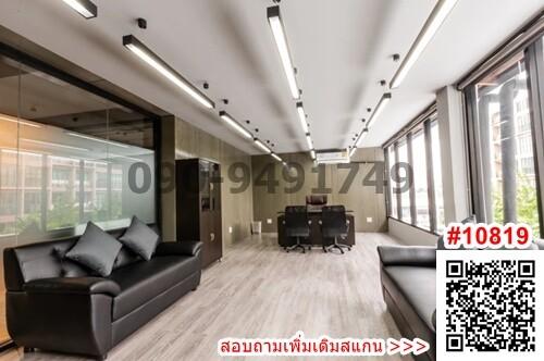 Modern office space with large windows and comfortable seating area