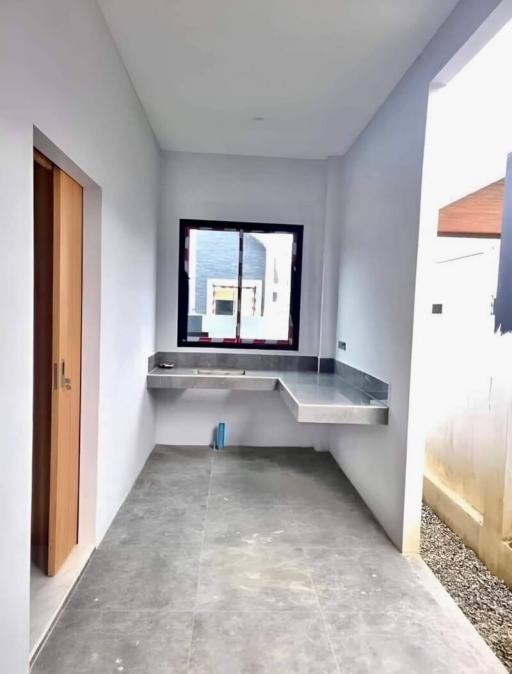 Minimalist kitchen under construction with large window and concrete countertops