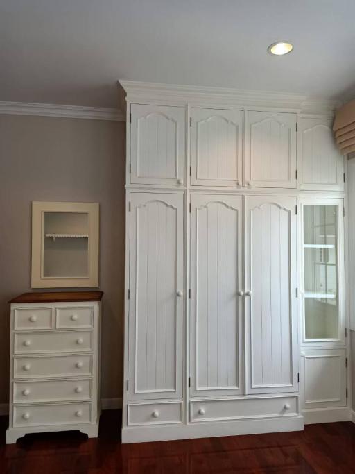 Elegant bedroom with white wardrobe and dresser