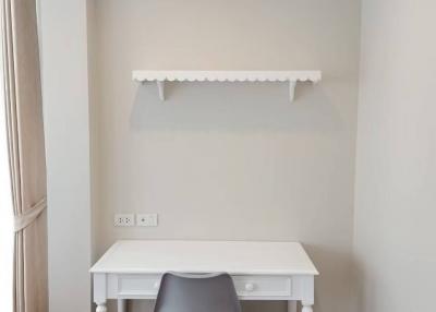 Minimalist bedroom interior with a white desk, chair, and air conditioner