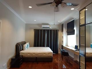 Spacious Bedroom with Modern Amenities and Work Area