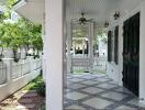 Elegant covered porch with patterned tile flooring and white wooden details