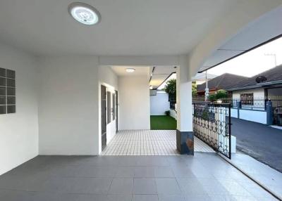 Spacious covered entrance of a modern residential building with tiled flooring