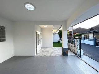 Spacious covered entrance of a modern residential building with tiled flooring