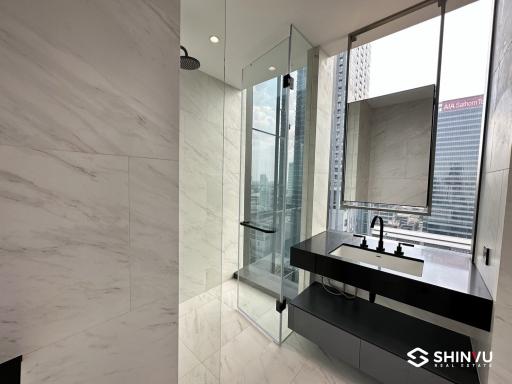 Modern bathroom with large glass shower and city view
