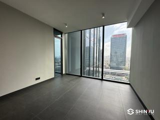 Empty interior space of a high-rise apartment with floor-to-ceiling windows and city skyline view