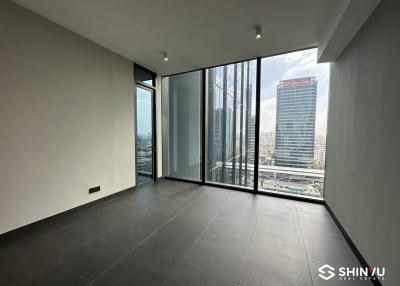 Empty interior space of a high-rise apartment with floor-to-ceiling windows and city skyline view