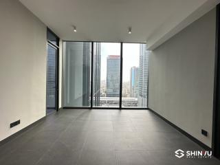 Empty high-rise apartment room with large windows and city view