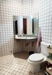 Compact bathroom with white tiles and a granite countertop