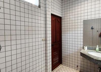 Spacious tiled bathroom with shower and vanity mirror
