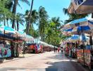 Vibrant outdoor market lined with stalls under palm trees