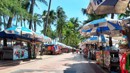 Vibrant outdoor market lined with stalls under palm trees