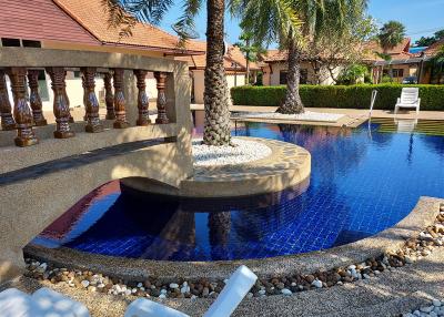 Elegant outdoor pool with curved design surrounded by a tropical garden