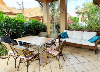 Spacious tile-floored patio with garden view, ample seating and natural lighting