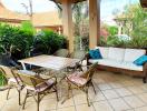 Spacious tile-floored patio with garden view, ample seating and natural lighting