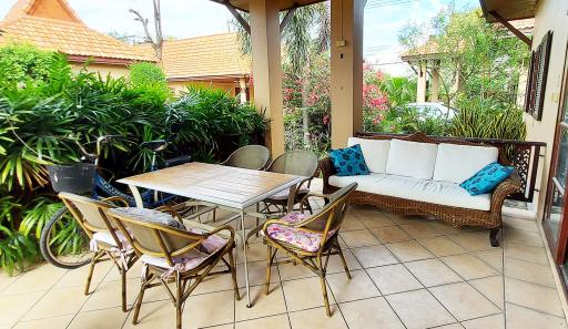 Spacious tile-floored patio with garden view, ample seating and natural lighting