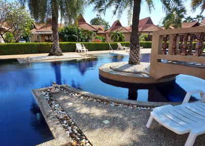 Luxurious resort-style poolside with lounge chairs and tropical landscaping