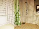 Bright bathroom interior with white tiles and green shower curtain