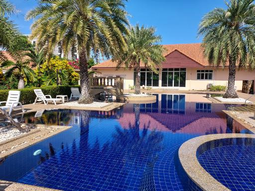 Luxury home exterior with swimming pool and palm trees