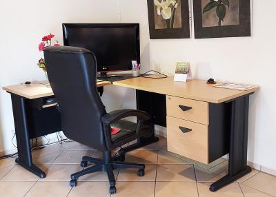 A well-organized home office space with a desk, a comfortable chair, and a television set