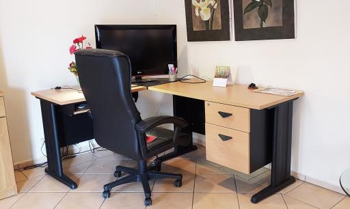A well-organized home office space with a desk, a comfortable chair, and a television set