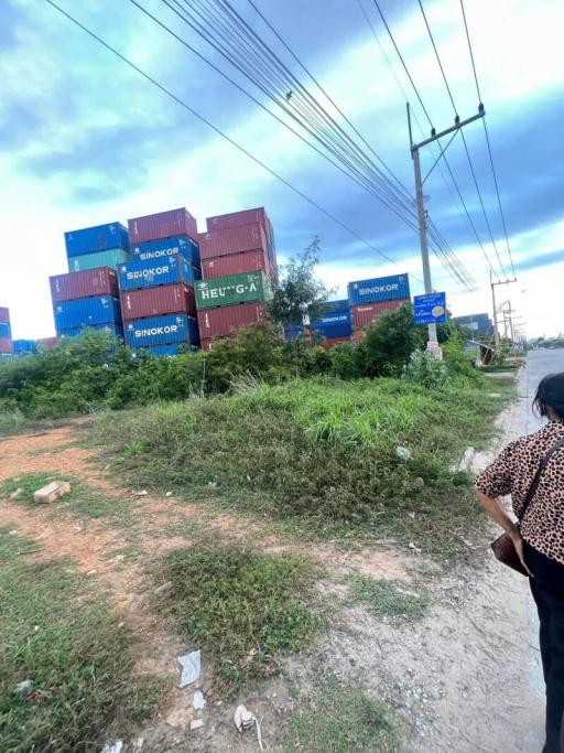 Stacked shipping containers on an industrial site with overcast sky