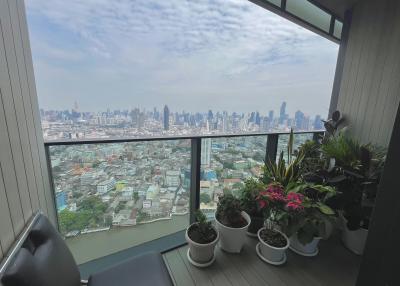 High-rise balcony with panoramic city view and potted plants