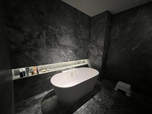 Modern bathroom with a standalone bathtub and marble walls