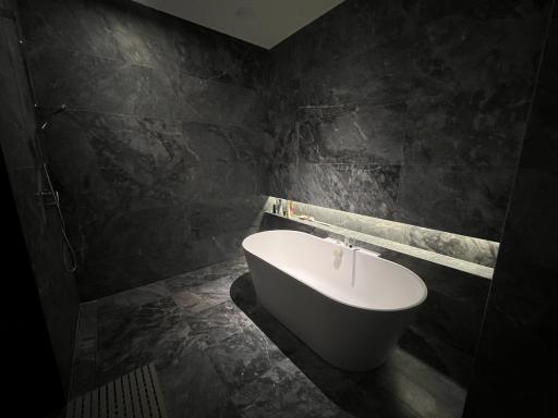 Modern bathroom with a free-standing bathtub and marble walls
