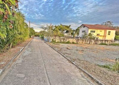 Paved road leading to a house with a clear blue sky