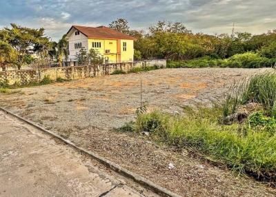 Exterior view with potential building lot in the foreground and a yellow house in the background