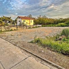 Exterior view with potential building lot in the foreground and a yellow house in the background