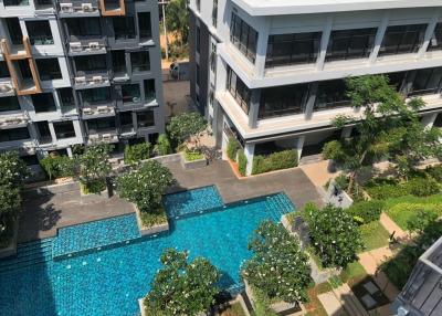 Aerial view of a modern residential building complex with swimming pool and garden