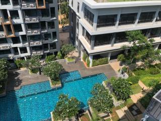 Aerial view of a modern residential building complex with swimming pool and garden