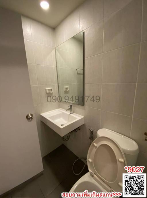 Compact bathroom with white tiles, sink, and toilet