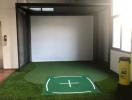 Indoor golf simulation room with artificial turf