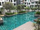 Communal swimming pool with surrounding garden in residential complex