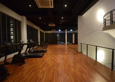 Spacious indoor gym with modern equipment and wooden flooring