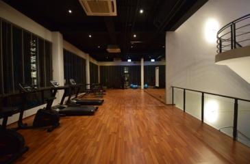 Spacious indoor gym with modern equipment and wooden flooring